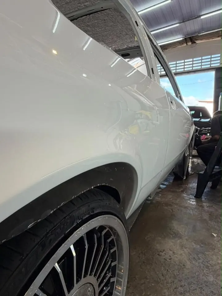 Carro branco com película de proteção sendo finalizado no estúdio